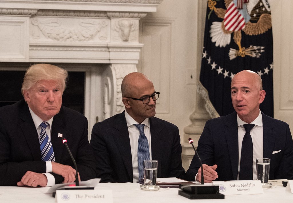 Amazon's Bezos and Microsoft's Nadella sit at Trump's table. Amazon's Bezos and Microsoft's Nadella sit at Trump's table.