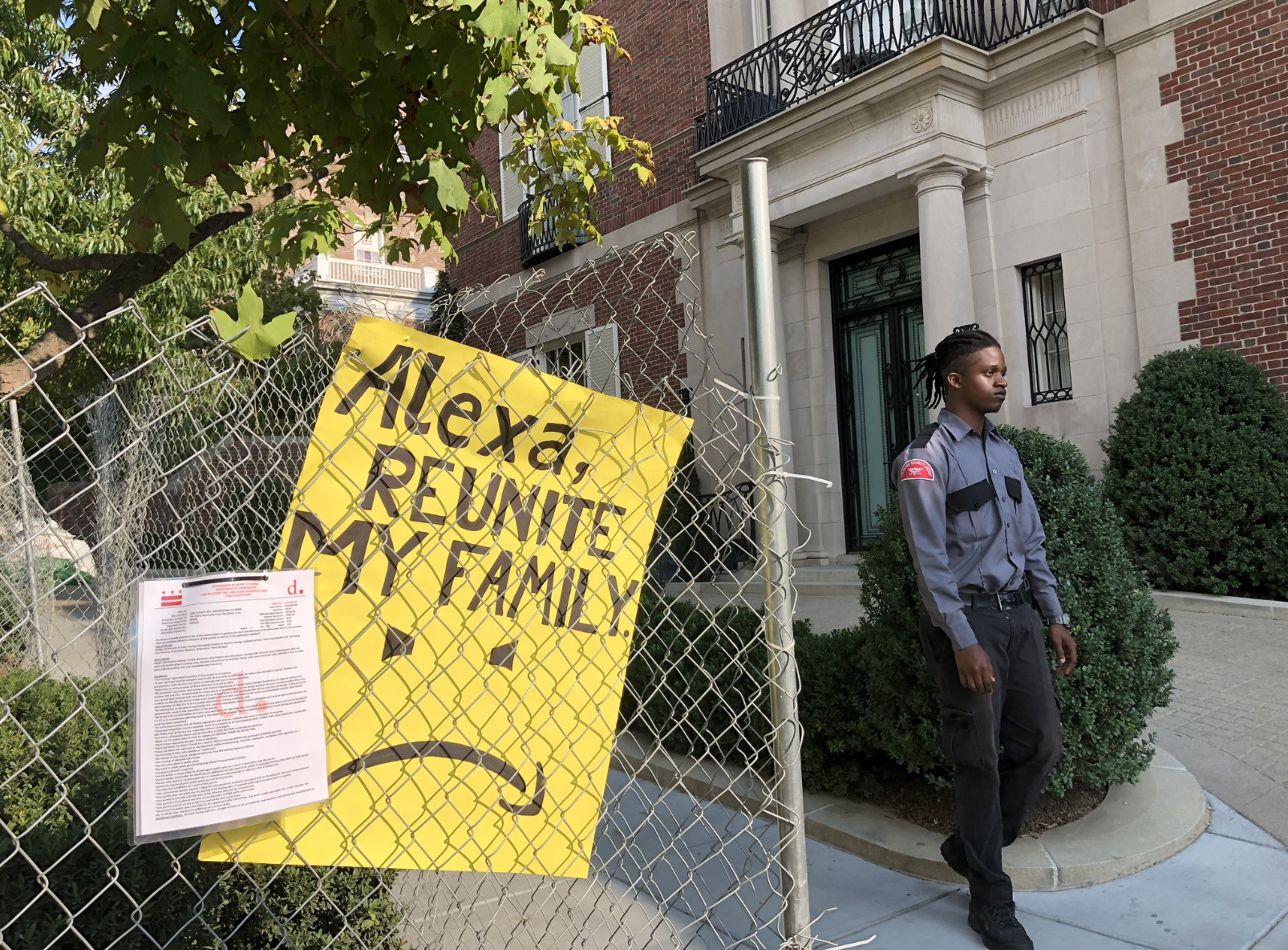 A poster on a fence reading 'Alexa, reunite my family' A poster on a fence reading 'Alexa, reunite my family'