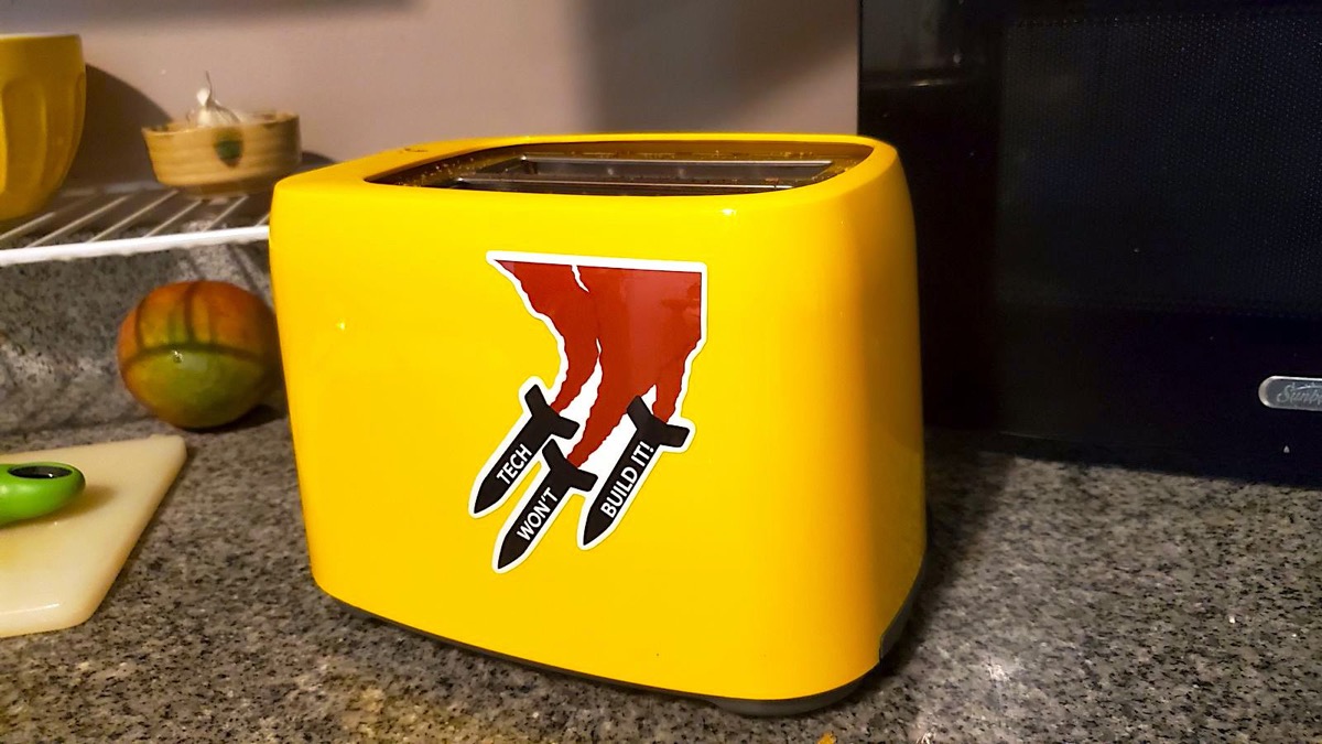 A yellow toaster with a sticker that says Tech Won't Build It A yellow toaster with a sticker that says Tech Won't Build It