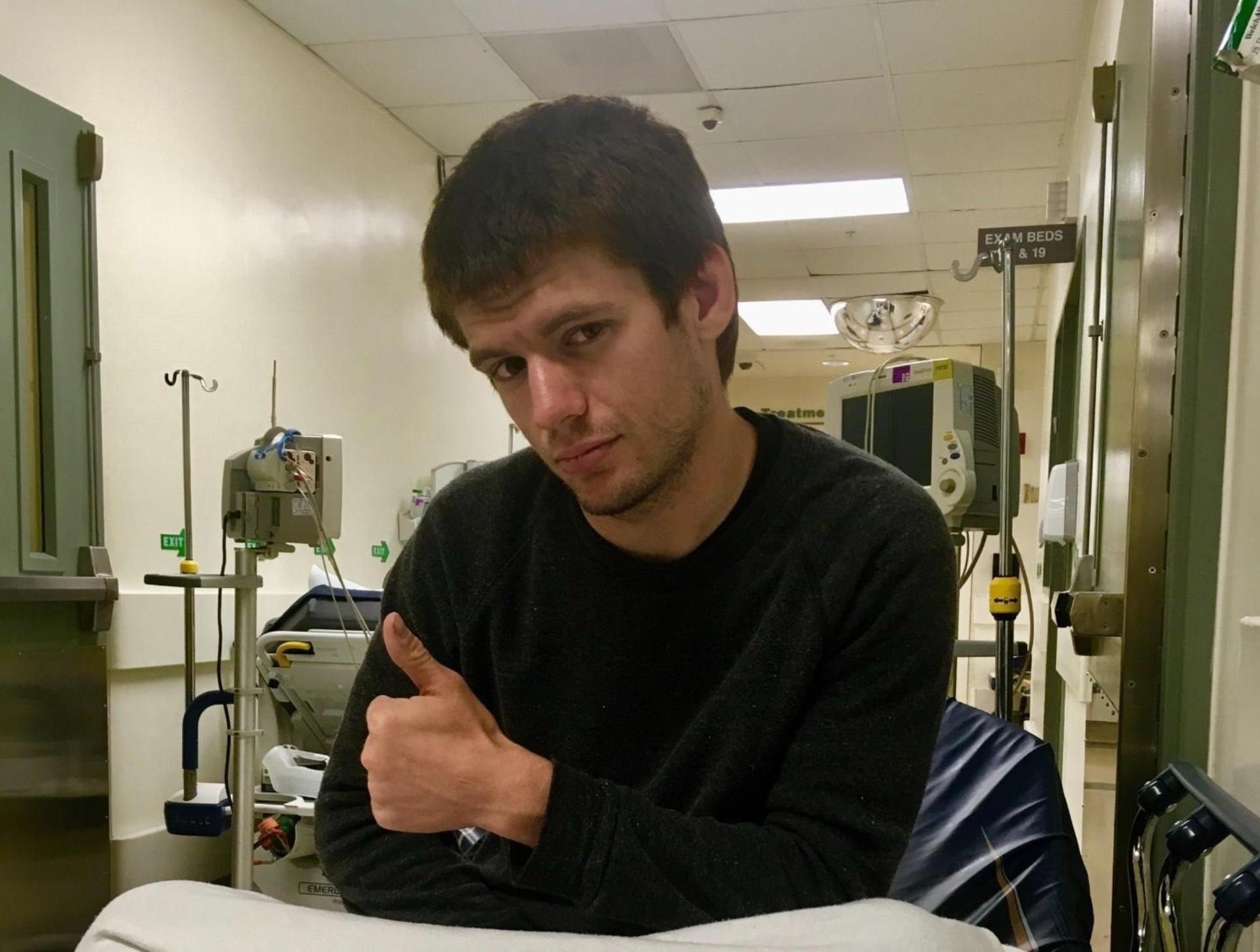 Andy sitting on a hospital bed and giving a thumbs up Andy sitting on a hospital bed and giving a thumbs up
