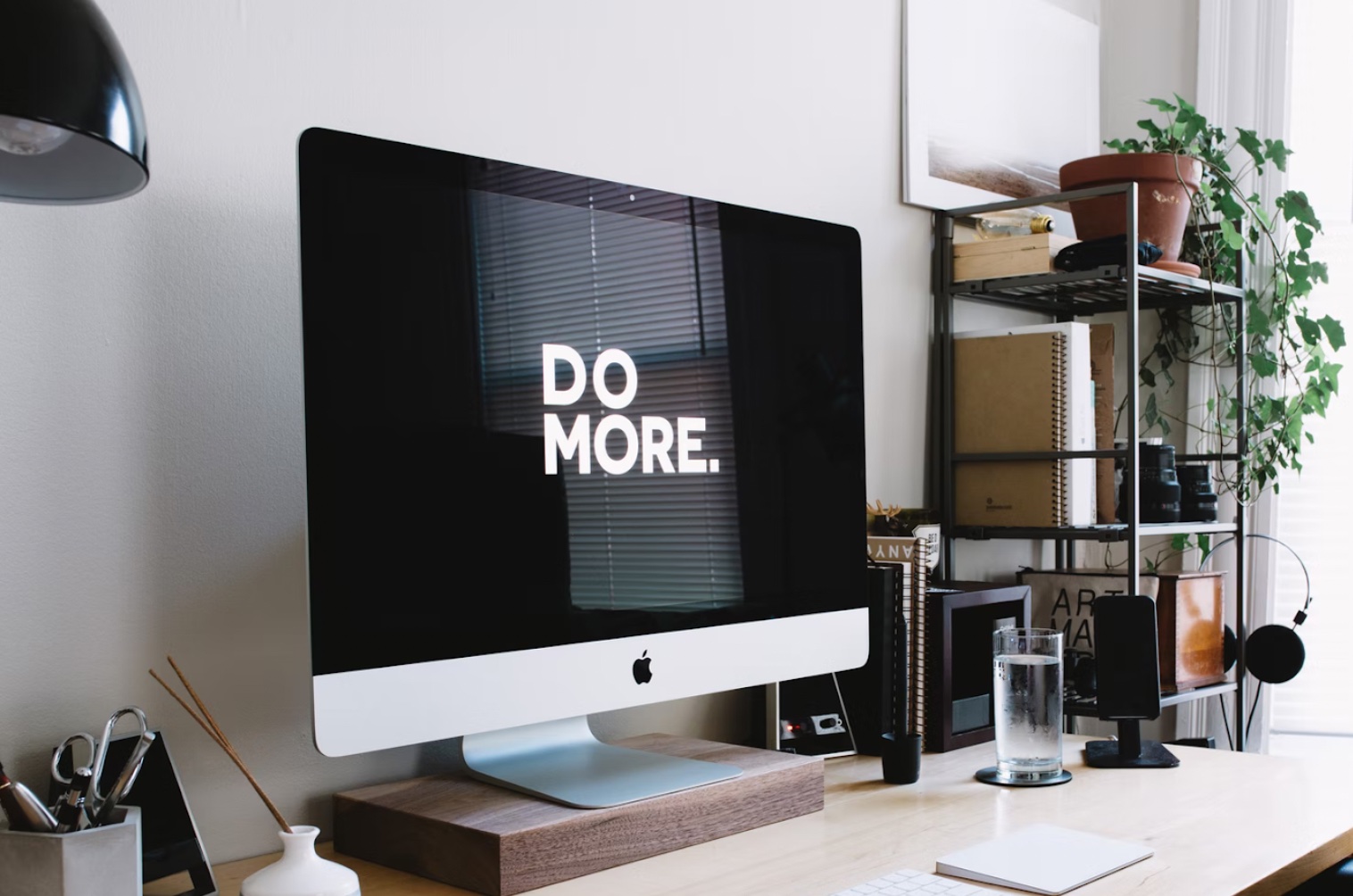A Mac monitor on a fancy but conventional desk reads Do More A Mac monitor on a fancy but conventional desk reads Do More